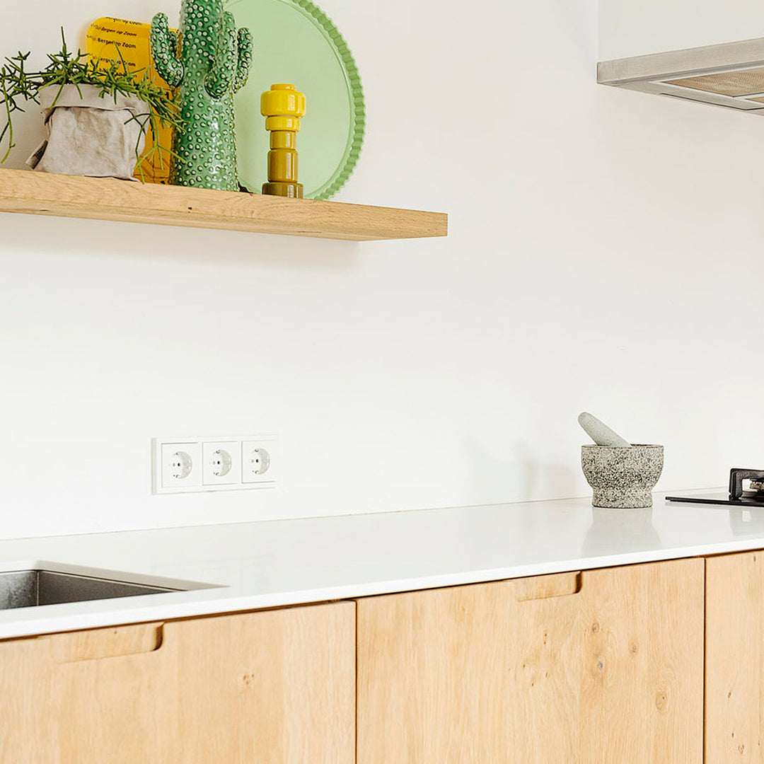 Wit Himacs keukenblad in houten keuken met grote wandplank