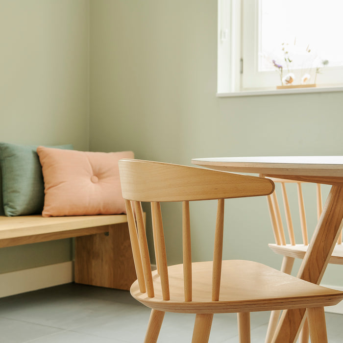 Tijdloze houten Hay stoelen aan een ronde tafel en houten zitbank op maat