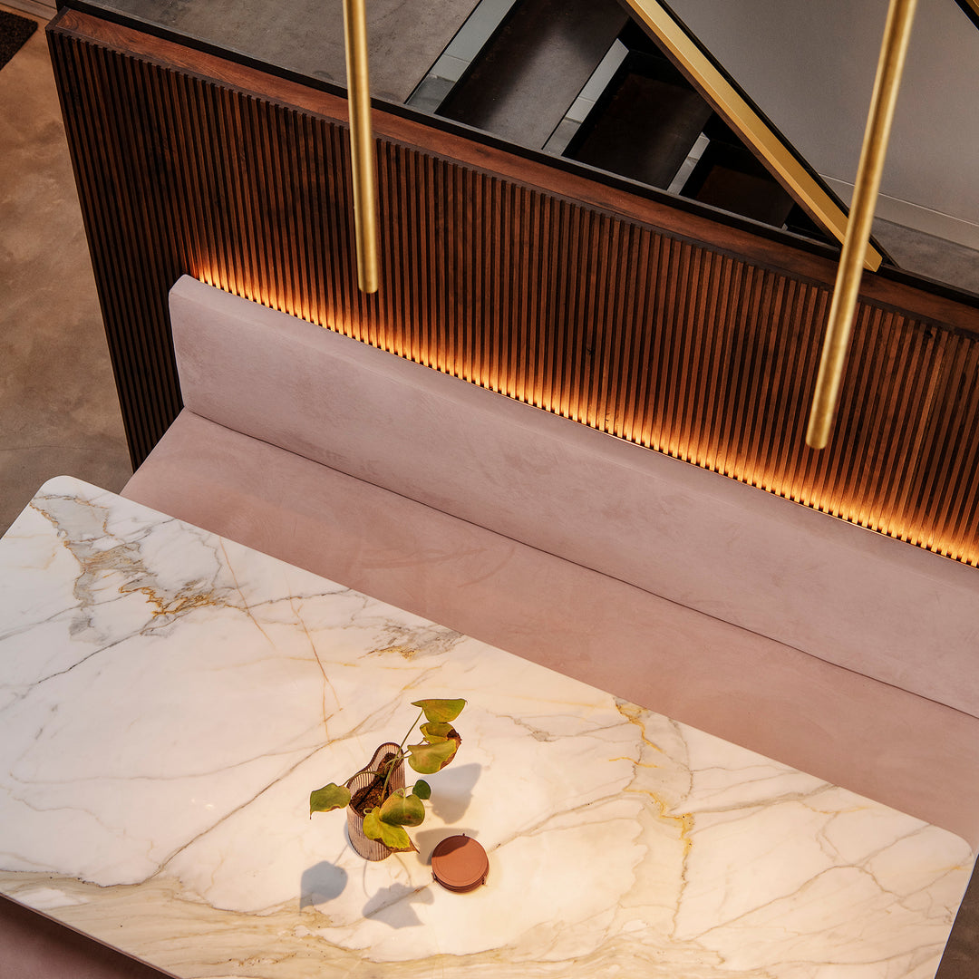 Maatwerk interieur met Davide Groppi verlichting, marmeren tafel, zwevende zitbank en gegraveerde wandpanelen