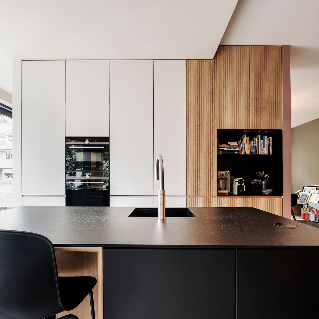 Kamerhoge keuken kasten in Fenix en gegraveerde houten fronten op maat, aansluitend op verschillende plafondhoogtes