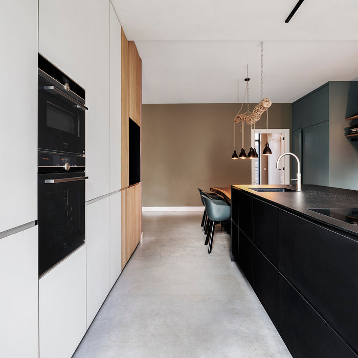 Maatwerk keuken met zwart kookeiland en kastenwand in massief hout en wit Fenix