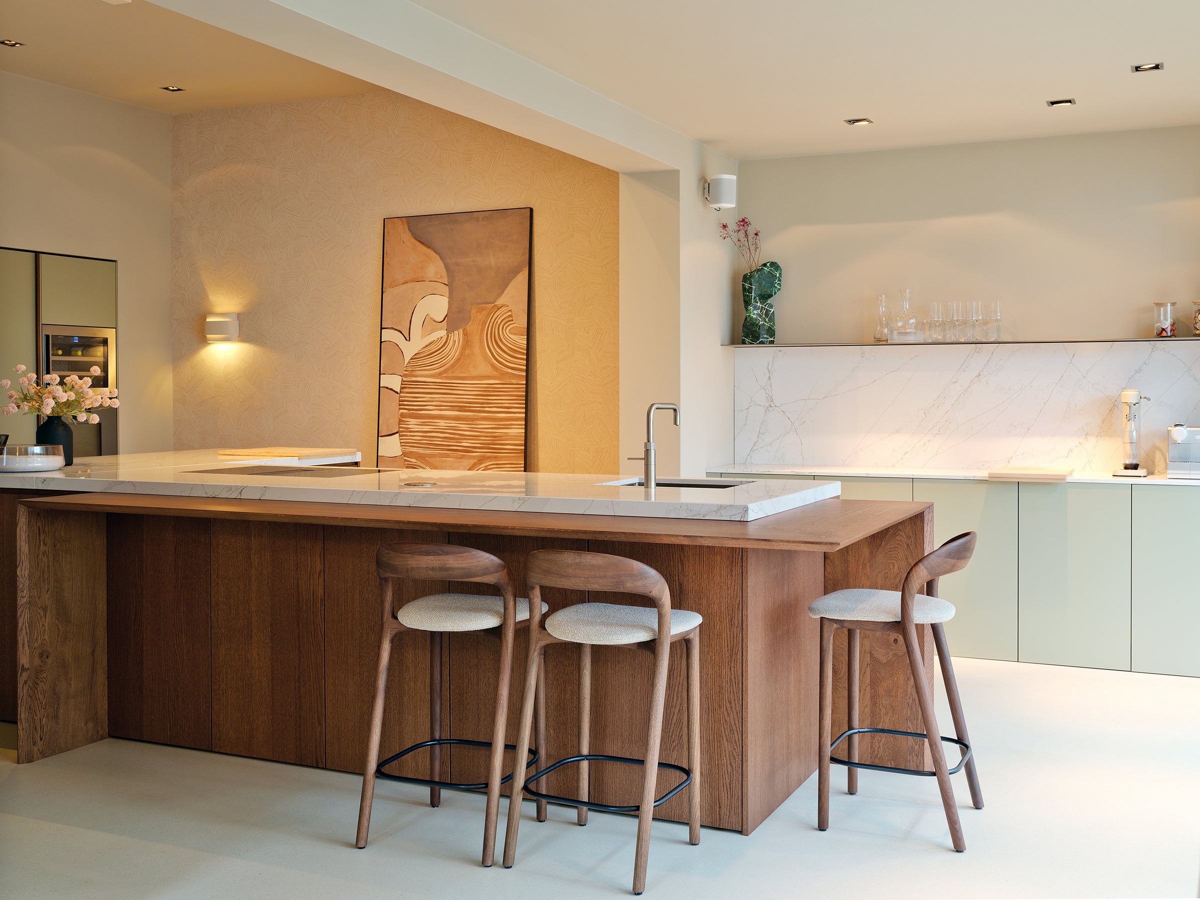 Een keuken met zitgedeelte op hoogte eettafel. Lage bar met comfortabele krukken. Eten aan je kookeiland.