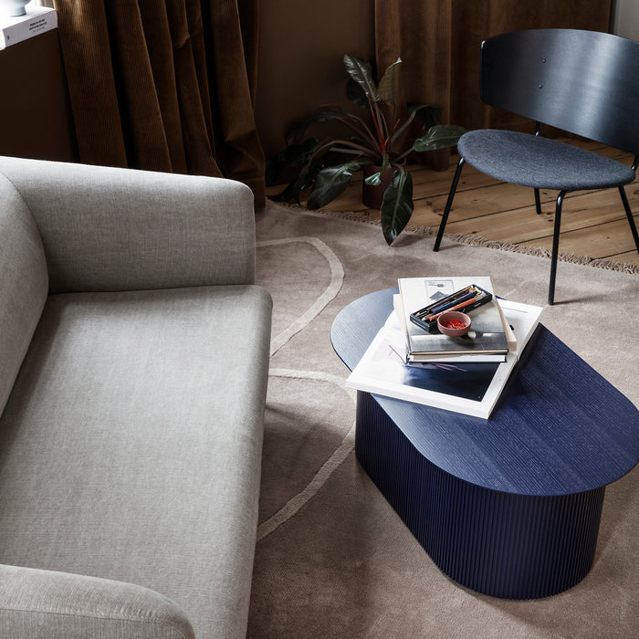 Stijlvol interieur met een Ferm Living Turn Sofa, donkerblauwe Podia salontafel en Herman Lounge stoel.