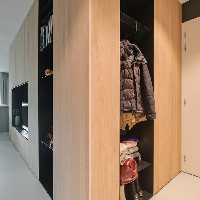 Grote houten kastenwand met veel opbergruimte en stalen garderobe nis kast voor jassen en schoenen 