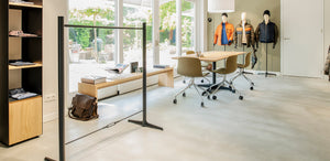 Maatwerk interieur voor detailhandel met houten tafel, wandkasten en kledingrekken op maat