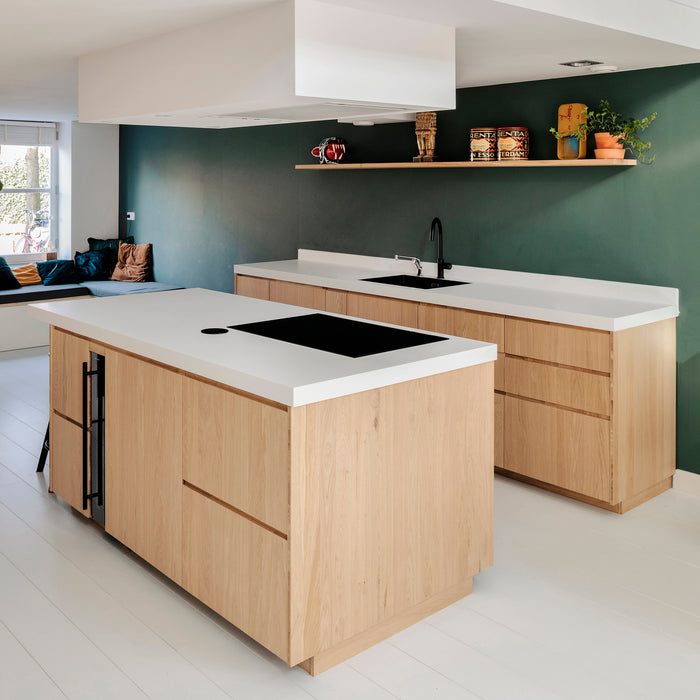 Houten keukenfronten in een lichte keuken met opgedikte Solid Surface werkbladen, quooker kraan en bora kookplaat