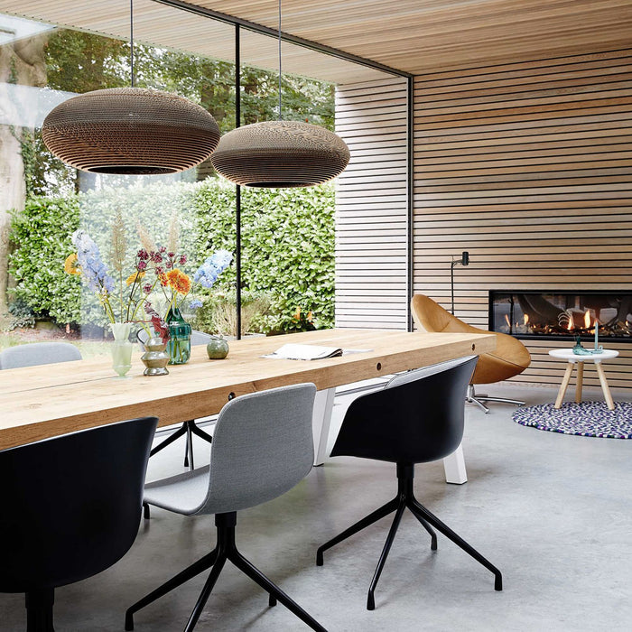 Modern interieur met lange stoere eiken maatwerk tafel en Hay stoelen