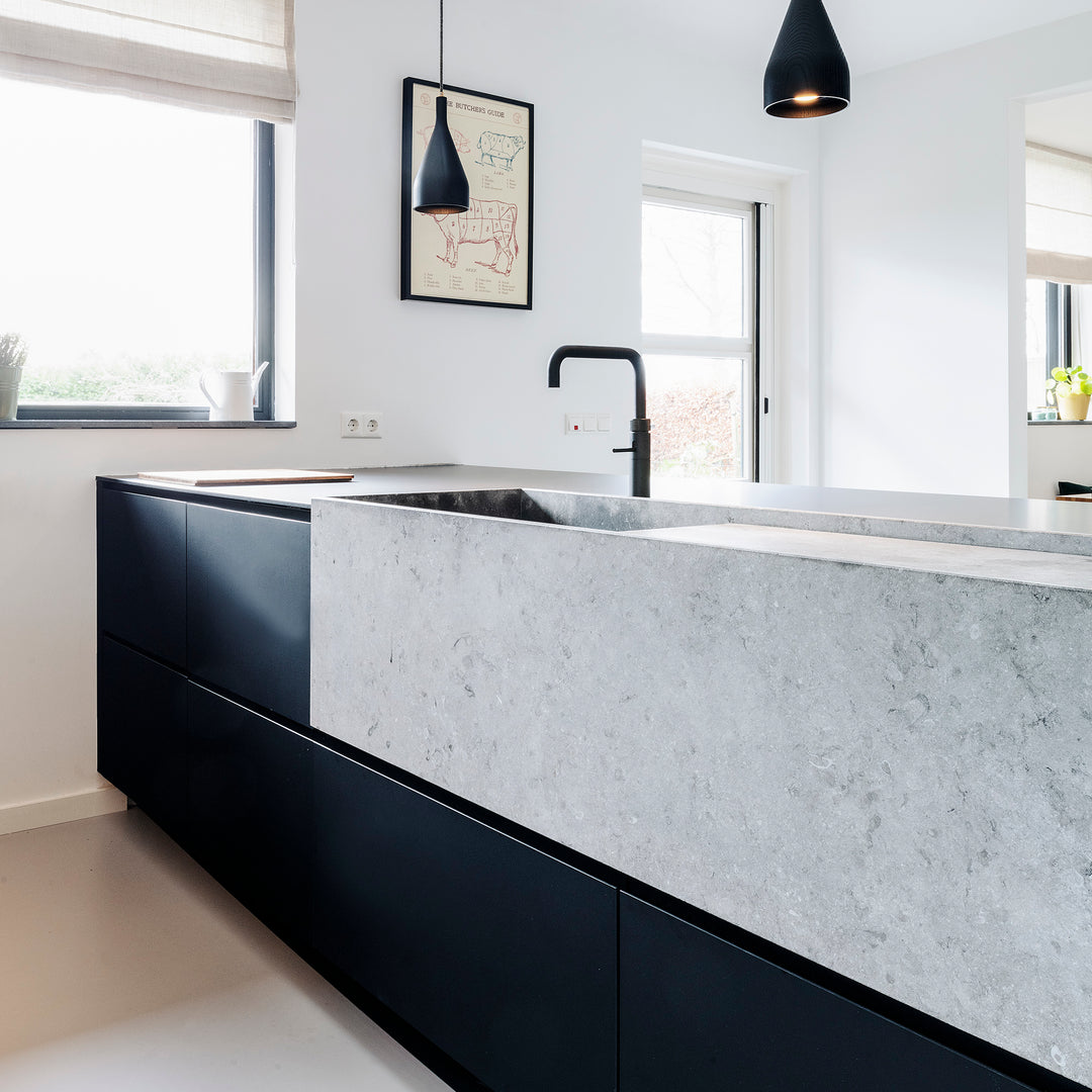 Grote stenen wasbak of trog in designkeuken met Quooker kraan